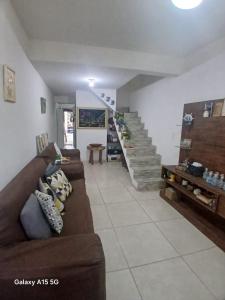 a living room with a couch and a staircase at Natureza e conforto na Praia da Brisa in Pedra de Guaratiba
