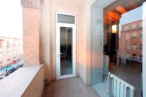 a building with a large glass door to a balcony at Balcony Modern Apartment Near Opera and Cascade, Middle of City Center in Yerevan