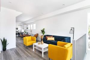 a living room with a blue couch and yellow chairs at Upscale LA Getaway Sleeps 8 with Free Parking in Los Angeles