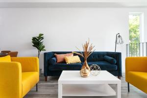 a living room with a blue couch and yellow chairs at Upscale LA Getaway Sleeps 8 with Free Parking in Los Angeles