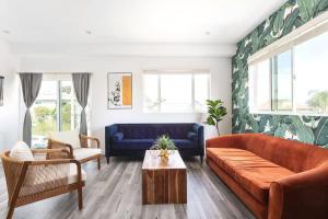 ein Wohnzimmer mit einem blauen Sofa und einem Tisch in der Unterkunft Prestige 5BR Townhome Near LA Hot Spots in Los Angeles