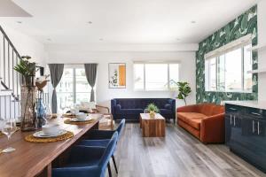 ein Wohnzimmer mit einem Tisch und blauen Stühlen in der Unterkunft Prestige 5BR Townhome Near LA Hot Spots in Los Angeles