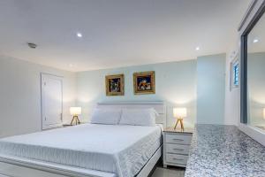 a bedroom with a white bed and two lamps at Apartamento Hermoso Frente Al Mar 11fl Amanzing in Villas del Mar +32 photos