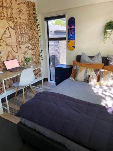 ブレナムにあるHome in Sunny Marlborough!のベッドと壁にスケートボードが掛かった机のある寝室