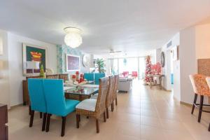 een woonkamer met een eettafel en blauwe stoelen bij Luxury Penthhouse Frente Al Mar in Villas del Mar