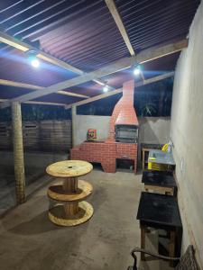 a room with a table and a brick oven at Casa Sítio in Rio Verde