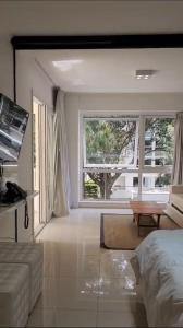 a living room with a bed and a large window at Green Park hermoso apartamento vista al lago in Punta del Este