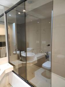 a bathroom with a toilet and a glass shower at Green Park hermoso apartamento vista al lago in Punta del Este
