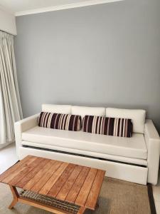 a white couch in a living room with a wooden coffee table at Green Park hermoso apartamento vista al lago in Punta del Este +52 photos