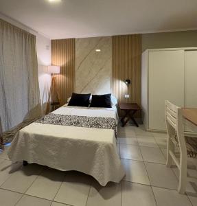 a bedroom with a large bed and a table at Paraná Suite Alem in Paraná