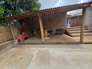 a covered patio with a table and a bench at Casa Sítio in Rio Verde