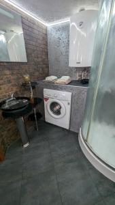 ein Badezimmer mit Waschmaschine und Waschbecken in der Unterkunft Смарт квартира в стилі лофт в самому центрі міста in Sumy
