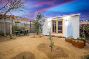 a small white house with a table in a yard at Coastal Bliss - 200m to beach in Rosebud