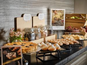 a buffet with various types of pastries and pies at Mercure Roma Centro Colosseo in Rome