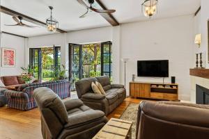 a living room with a couch and a tv at The Warehouse - Heritage Elegance in Central Mudgee in Mudgee