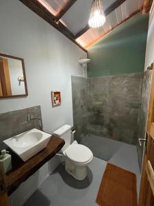a bathroom with a toilet and a sink at Dona Canoa Hospedaria in Porto Seguro