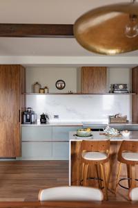 Una cocina con gabinetes de madera y un mostrador con taburetes. en Bond Store Stanley, en Stanley