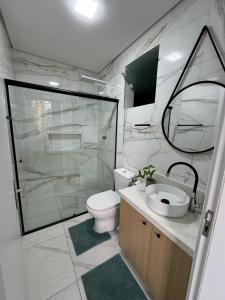 Un baño con inodoro, lavabo y ducha. en Pousada Morada Madu, No Centrinho Da Praia do Rosa, en Praia do Rosa