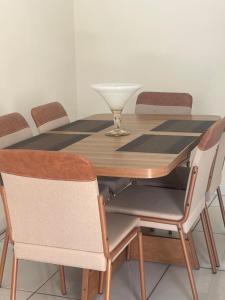 a wooden table with four chairs and a bowl on top at Casa João in Petrolina