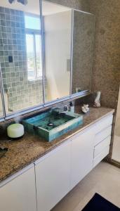 a bathroom with a green sink and a mirror at Quarto Vista Mar in Recife +12 photos