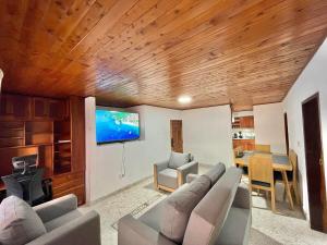 Una sala de estar con un sofá y un televisor de pantalla plana. en Navidad en familia 2 hab balcón cerca CC Mayorca, en Sabaneta