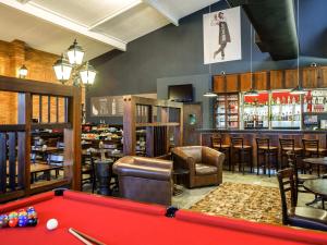 a billiard room with a pool table and a bar at Ibis São Carlos in São Carlos
