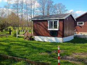 a small house in a yard with a grass field at 5 star holiday home in Odder in Gylling