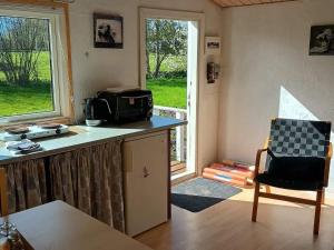 a kitchen with a microwave on a counter and a chair at 5 star holiday home in Odder in Gylling