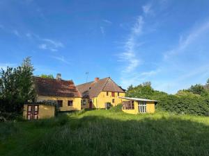 an old yellow house in a field of grass at 5 star holiday home in Søby Ærø in Søby