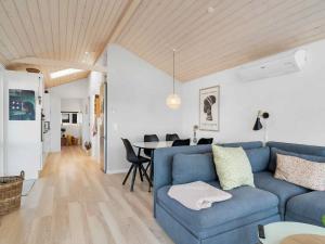 a living room with a blue couch and a table at 5 star holiday home in Karrebæksminde in Karrebæksminde