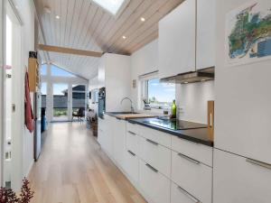 a kitchen with white cabinets and a large window at 5 star holiday home in Karrebæksminde in Karrebæksminde +13 photos