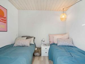 a bedroom with two beds and a night stand at 5 star holiday home in Karrebæksminde in Karrebæksminde