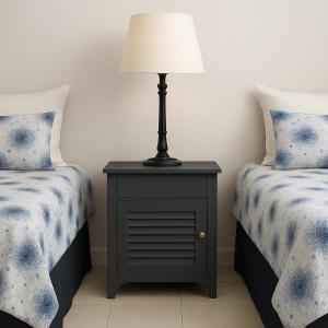 a lamp on a night stand next to two beds at 87 on Sunbird in Langebaan