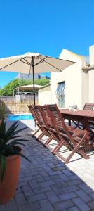 a table and chairs with an umbrella next to a pool at 87 on Sunbird in Langebaan