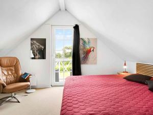 a bedroom with a large red bed and a chair at 5 star holiday home in Brenderup Fyn in Åbjerg