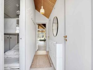 a hallway leading to a bedroom with a bed and a mirror at 5 star holiday home in Jægerspris in Hornsved