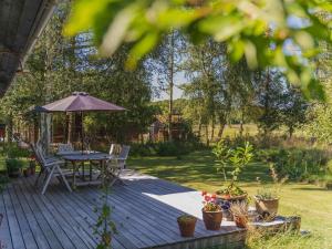 a wooden deck with a table and an umbrella at 5 star holiday home in Gørlev in Ornum
