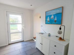 Pugdalにある4 star holiday home in Hanstholmの壁に船の絵が飾られた白いドレッサーのある部屋