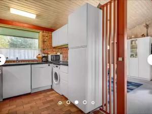 a kitchen with white appliances and a window at 5 star holiday home in Ørsted in Udbyhøj