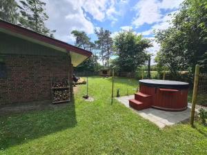 a backyard with a hot tub in the grass at 5 star holiday home in Ørsted in Udbyhøj