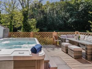 a hot tub on a deck with a table and chairs at Waterside Lodge in Elland