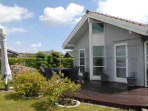 a house with a deck with chairs and a table at 5 star holiday home in Karrebæksminde in Karrebæksminde