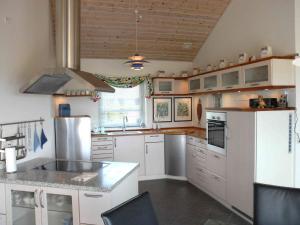 a kitchen with white cabinets and a stove top oven at 5 star holiday home in Karrebæksminde in Karrebæksminde