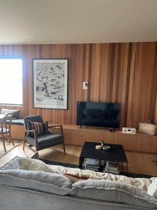Una sala de estar con un sofá y un televisor. en Tranquil 3 bedroom Retreat in Raglan, en Raglan