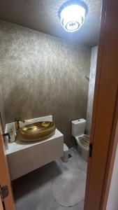 een badkamer met een gouden toilet op een aanrecht bij Edifício LISSE in Belém +9 foto's