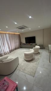 een woonkamer met twee witte banken en een flatscreen-tv bij Edifício LISSE in Belém