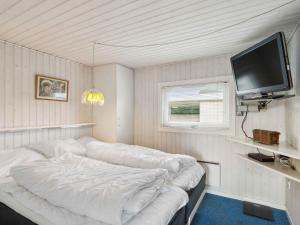 a white room with a bed and a flat screen tv at 5 star holiday home in Strøby in Strøby Ladeplads +13 photos