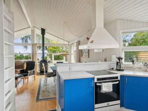 a kitchen with blue and white appliances and a living room at 5 star holiday home in Strøby in Strøby Ladeplads