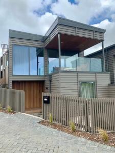 una casa con una valla delante en Tranquil 3 bedroom Retreat in Raglan, en Raglan