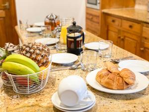 a table with plates of food and bananas and croissants at Anneth Lowen in Pentewan